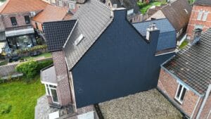Plat dak met grindlaag en afgewerkte dakrand naast een hellend dak